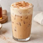 Iced banana bread chai in a clear glass topped with brown sugar cold foam and cinnamon sugar.